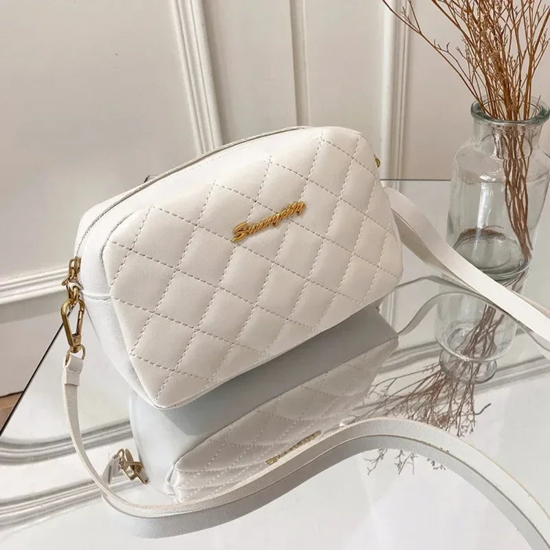 SUVETTE white quilted crossbody bag on glass table