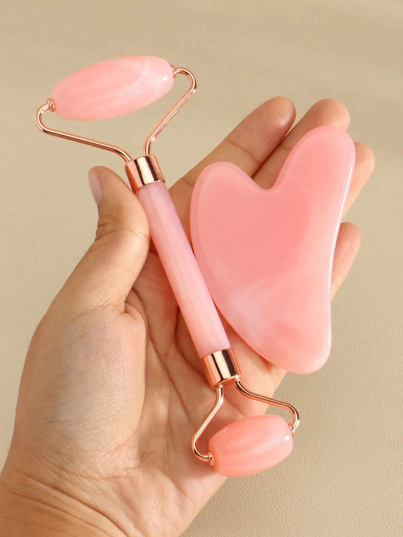 SUVETTE pink facial roller and gua sha tool set in hand